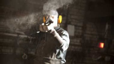 Demirci sıcak bıçağı soğuk su kovasında soğutuyor.