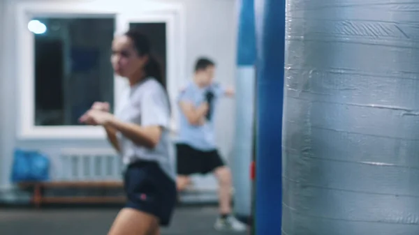 Мужчины и женщины, тренирующиеся в тренажерном зале - женщина, занимающаяся теневым боксом — стоковое фото