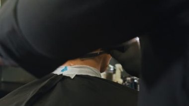 Bir berber son dokunuşlarını saçının kenarlarındaki tehlikeli bıçakla yapar.