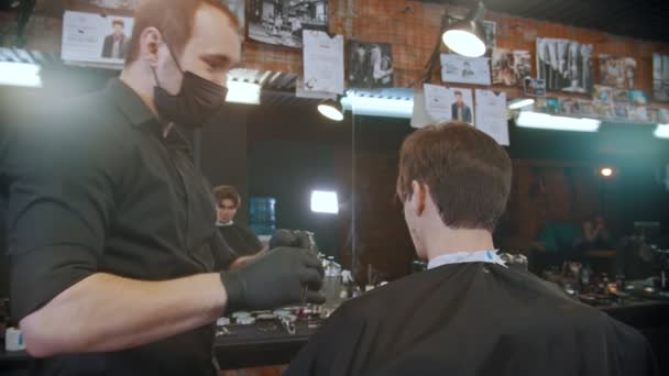 戴黑色面罩的理发师在头发边缘用危险的刀片做最后润肤 — 图库视频影像