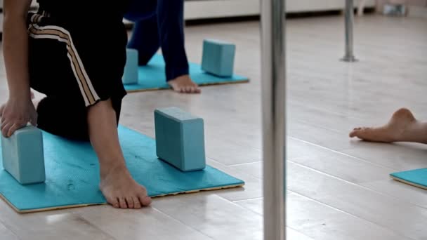Fazendo exercício em tapetes de ioga com inclinação sobre os tijolos sob as mãos — Vídeo de Stock