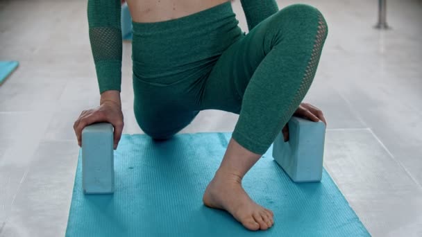 Doing exercise on yoga mat with leaning on the bricks under hands — Αρχείο Βίντεο