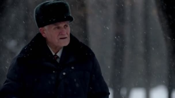 Elderly grandfather - lost grandfather is walking in the winter park — Stockvideo