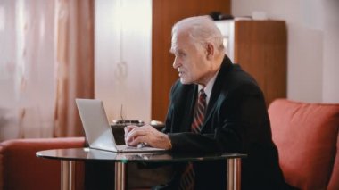 Elderly grandfather - old grandfather is talking at the desk