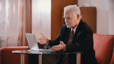 Elderly grandfather - old grandfather is swearing at a computer