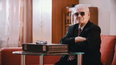 Elderly grandfather - old grandfather is sitting with glasses and crossed arms