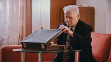 Elderly grandfather - old grandfather is slowly reloading weapon in his room