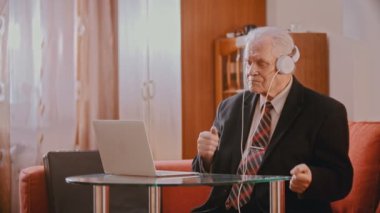 Elderly grandfather - aged grandfather in headphones dancing to the music