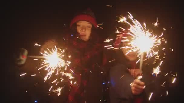 Two young women playing with sparklers outdoors at night — Stock Video