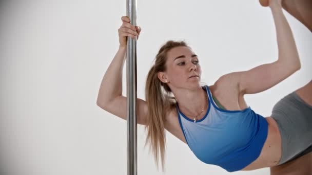 Jeune femme formant sa jambe étirant avec son entraîneur tandis que la formation de pole dance — Video