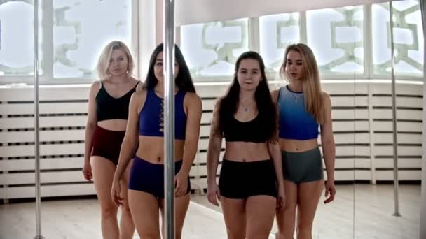 Quatro mulheres esportivas andando e ficar ao lado do pólo para pole dancing no estúdio — Vídeo de Stock