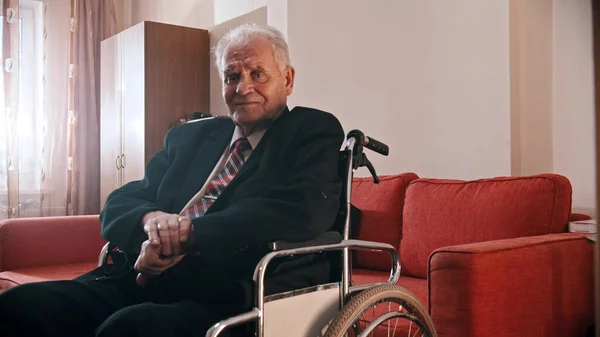 Elderly grandfather - smiling grandfather sitting in a wheelchair — Stockfoto