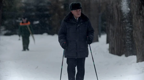 Літній дідусь - старий дідусь робить піші прогулянки в зимовий час в парку — стокове фото