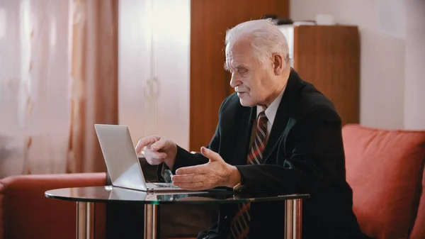 Un viejo hombre de negocios apuntando a la laptop — Foto de Stock