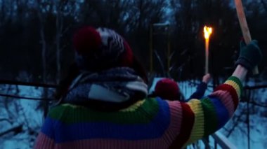 Köprüde ellerinde meşalelerle koşan iki genç bayan arkadaş.