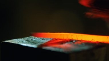 Demirci sıcak metal parçalarını temizliyor.