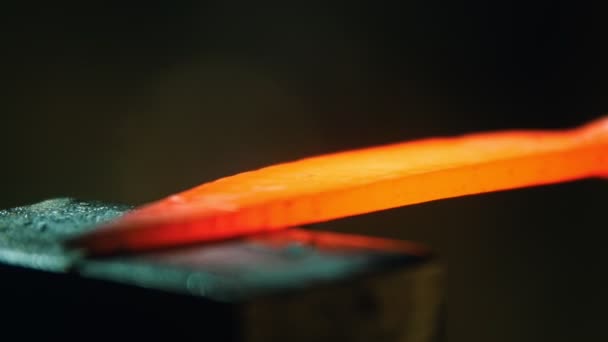 Blacksmith hitting the piece of hot metal - small pieces comes off the metal — Stock Video