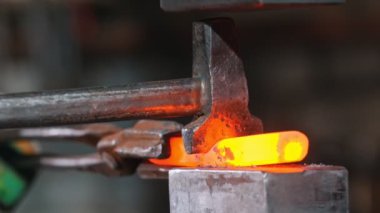 Demirci, akkor metali baltayla ve endüstriyel baskı makinesiyle kesiyor.