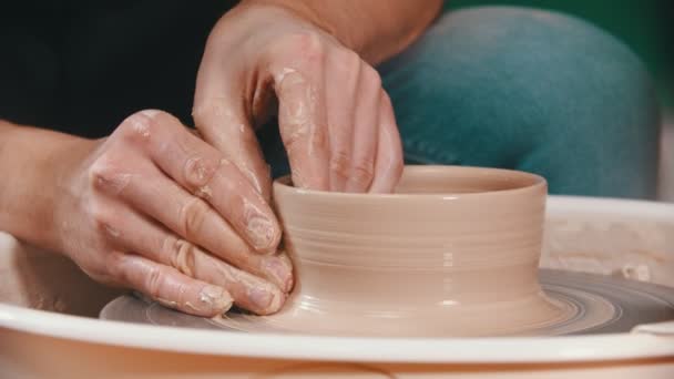Керамика - мастер поднимает стены глиняной чаши руками на гончарный круг — стоковое видео