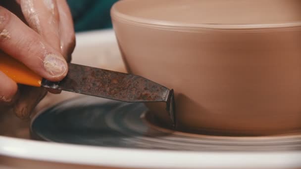 Ceramiche - il maestro si sta aiutando a rimuovere l'argilla in eccesso con uno speciale strumento di modellazione nel laboratorio creativo — Video Stock