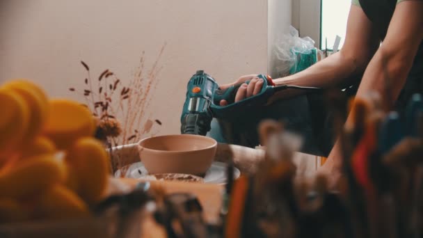 Aardewerk - meester in is het drogen van een klei kom met een bouw haardroger oplichting het pottenbakkerswiel — Stockvideo