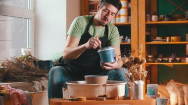 Çanak çömlek - usta mavi boyalı bir kase boyuyor
