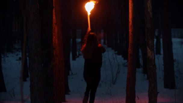 Молодая женщина бежит в ночном зимнем лесу — стоковое видео