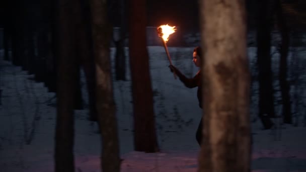 年轻女子从夜林中的某个地方拿着火把跑出来 — 图库视频影像