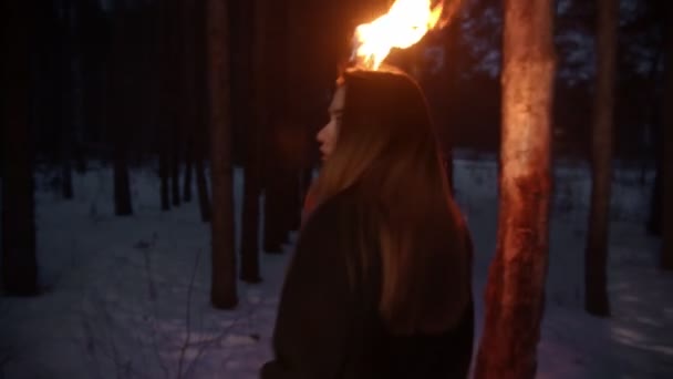 Młoda wystraszona kobieta z pochodnią uciekająca przed niebezpieczeństwem w nocnym lesie — Wideo stockowe