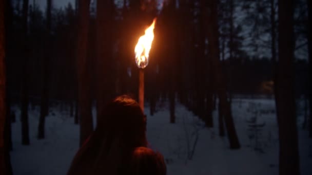 Jeune femme effrayée avec une torche de feu fuyant le danger dans la forêt nocturne — Video