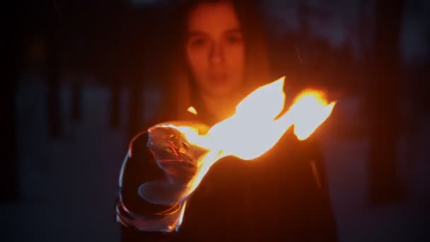 Mujer joven de pie al aire libre por la noche con una antorcha de fuego — Vídeos de Stock