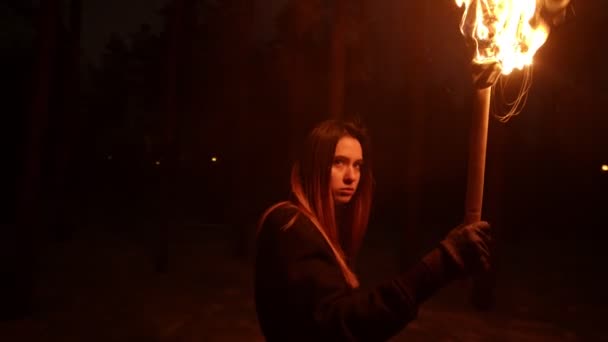 Femme perdue avec une torche de feu marchant dans la forêt nocturne et trouvant une issue — Video