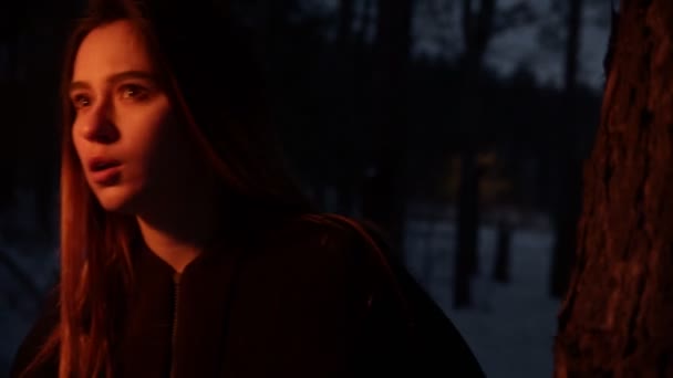 Jeune femme effrayée avec torche marchant dans la forêt sombre 