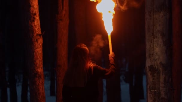 Woman walking in the woods at night time holding a torch — Stock Video