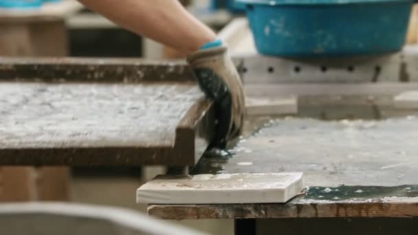 Человек-рабочий моет бетонную плиту тряпкой и водой в мастерской — стоковое видео