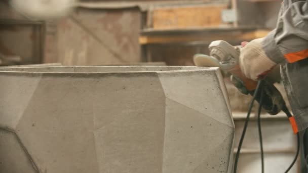 Industria del hormigón - trabajador puliendo una gran figura de hormigón con una amoladora — Vídeo de stock