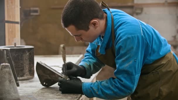 Бетонна промисловість в майстерні - людина працівник прибирає форму для вилучення бетону з залишків — стокове відео