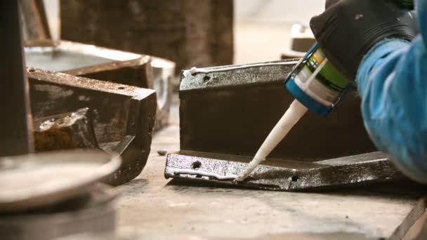 Indústria de concreto - jovem trabalhador aplicando cola por parte de todo o detalhe — Vídeo de Stock