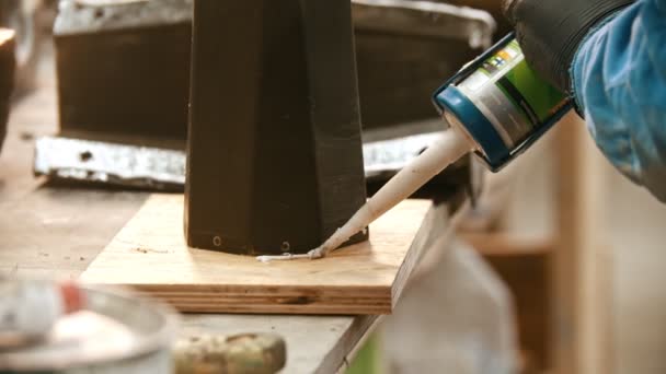 Industrie du béton - jeune homme travailleur appliquant de la colle sur le support en bois — Video