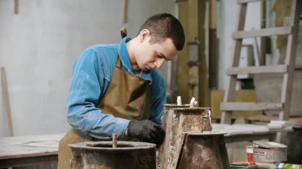 Concrete industry - young man working with concrete details in the workshop - adding screws to it — Αρχείο Βίντεο