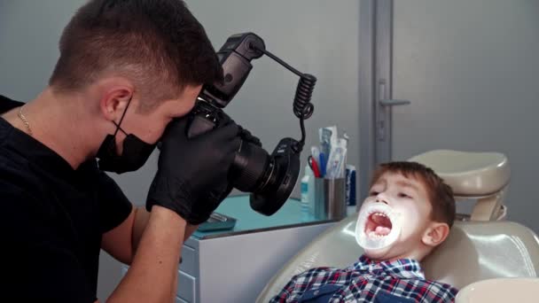 Ein kleiner Junge bei einer Behandlung in der Zahnmedizin - der Junge mit geöffnetem Mund — Stockvideo