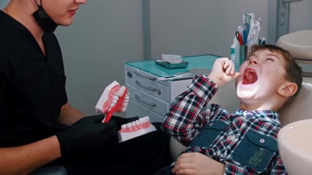 Egy kisfiú, akinek kezelése van a fogászatban - a higiénia és a fogmosás megvitatása — Stock videók