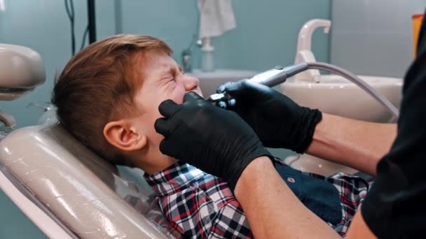 Een kleine jongen die zijn tanden laat doen in de tandheelkunde — Stockvideo