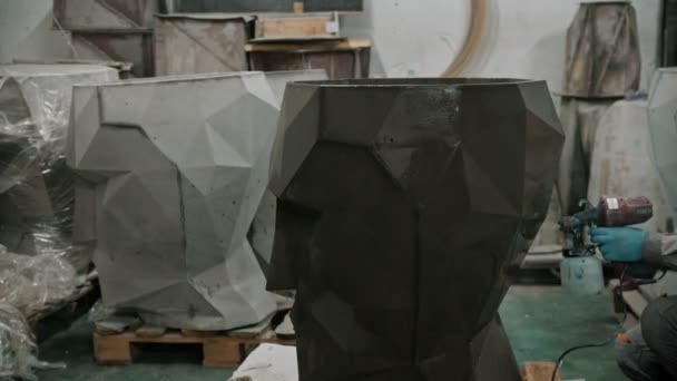 Бетонна промисловість - працівник, який малює великий бетонний предмет темнішим кольором — стокове відео