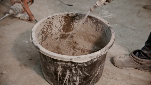 Concrete industry - worker adding water in the bucket full of dry cement — Stock Video