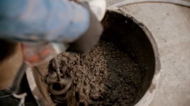 Beton endüstrisi - bir el mikseri kullanarak kovaya beton karıştırmak