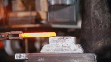 Forging an item out of hot metal using a pressure machine