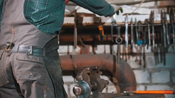 Forging industry - a man blacksmith cleaning the workshop — Stock Video