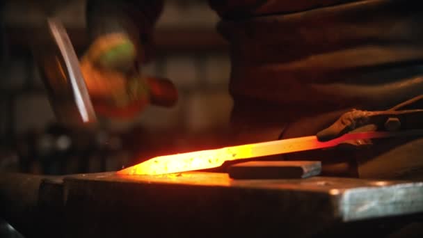 Herrero trabajando en el taller - hombre calentando la pieza de metal en el horno y golpeándolo con un martillo — Vídeos de Stock