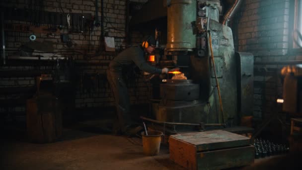 Кузнечная промышленность - человек-кузнец, работающий с горячим металлом в цехе — стоковое видео
